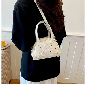 Detailansicht der weißen Polka-Dot-Handtasche mit Spitze und Schleifen als Umhängetasche