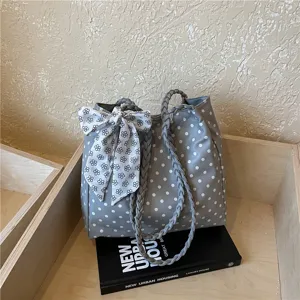 Stylish retro grey polka dot tote bag with braided handles and a floral bow detail.