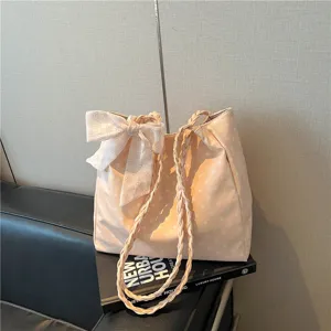 Stylish peach polka dot tote bag with large bow and braided straps for daily use