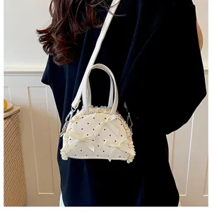 Detailansicht der kleinen weißen Tasche mit Punkten, Spitze und Schleifendekor
