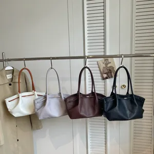 Stylish pleated cloud-shaped underarm bags in multiple colors hanging on a rack