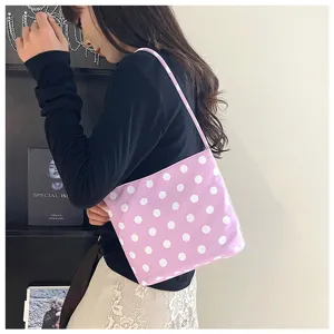 Bolso de hombro informal morado con lunares blancos en una escena detallada de estilo de vida