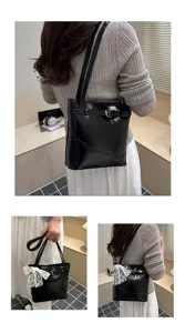Dettaglio borsa shopper nera capiente con fibbia e fiocco in pizzo decorativo