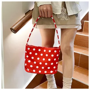 Bolso de hombro rojo con lunares blancos para mujer en un entorno moderno