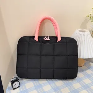 Borsa trapuntata per laptop 14-16 pollici con manici rosa in un ambiente accogliente