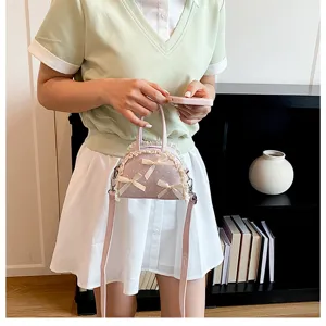 Detailansicht einer rosa gepunkteten Handtasche mit Spitzenbesatz und Schleifen