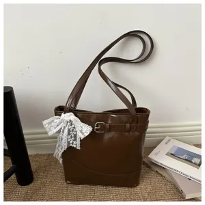 Borsa a secchiello minimalista marrone con fiocco in pizzo bianco e dettaglio fibbia cintura.
