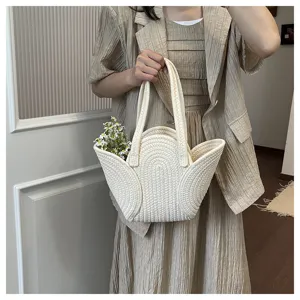 Vue détaillée d'un sac cabas tissé crème avec un design unique en forme de pétale.