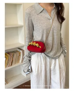 Modella che indossa una borsa da sera rossa minimalista con decorazione in oro
