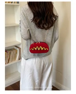 Borsa da sera rossa con dettaglio dorato ondulato indossata da una modella stile retrò