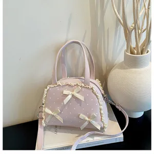Detailansicht der rosa gepunkteten Handtasche mit Spitzenbesatz und Schleifen