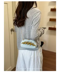 Elegante borsa da sera azzurra con dettaglio in metallo dorato ondulato e catena