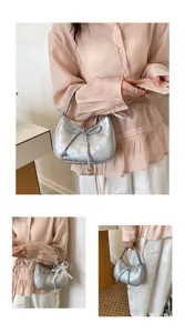 Silberne Schleifen-Tasche am Model gezeigt, perfekt für den täglichen Pendelverkehr.