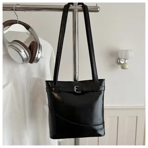 Borsa a secchiello nera in ecopelle con fibbia decorativa in ambientazione lifestyle