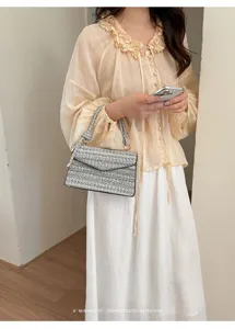 Primo piano di un elegante borsa a tracolla quadrata minimalista in tessuto da donna