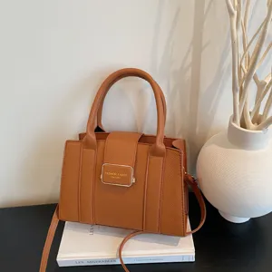 Stylish brown pebbled leather tote bag with top handles and adjustable shoulder strap