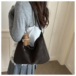 Sac hobo rétro marron foncé porté par un mannequin avec un joli charme de chien