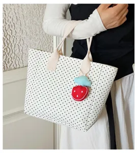 High-capacity white polka dot canvas tote bag featuring a cute strawberry charm