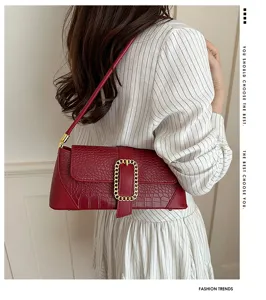 Detailed look at the red croc-embossed French baguette shoulder bag on a model.