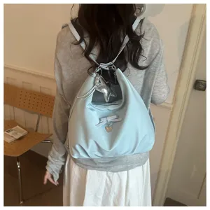 Light blue multi-functional backpack with star pendant shown being worn as a rucksack