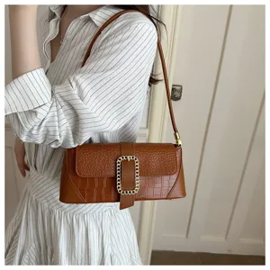 Close-up of a brown stone pattern baguette underarm bag with a gold chain buckle on a model