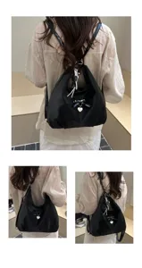 Versatile black large capacity nylon backpack with a stylish heart pendant and bow detail