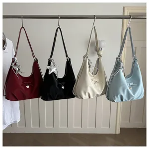 Selection of four chic hobo shoulder bags with heart and star charms hanging on a metal rail
