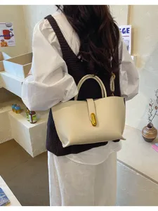 Elegante bolso tipo cubo de cuero crema con cierre dorado para oficina y estilo diario chic