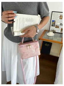 Borsa a mano a scatola in jacquard rosa con farfalla applicata in contesto lifestyle