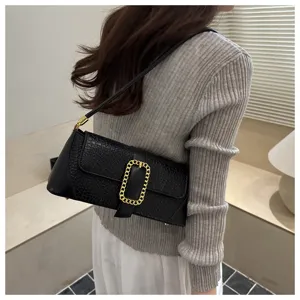 Elegant black crocodile pattern underarm baguette bag showcased on a fashion model