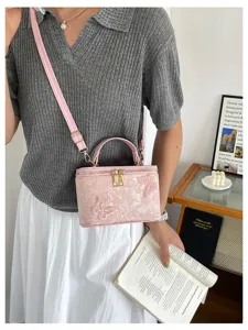 Dettaglio della borsa a scatola in jacquard rosa con pizzo a farfalla su un modello