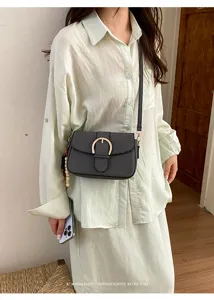 Sophisticated retro style women's textured crossbody bag with gold buckle detail