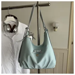 Detail view of light blue hobo bag with decorative bow and star charm on rack