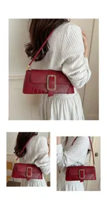 Close-up of wine red crocodile embossed baguette bag with gold buckle detail