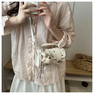 Detailed view of the cute white polka dot pillow bag styled with a summer outfit.