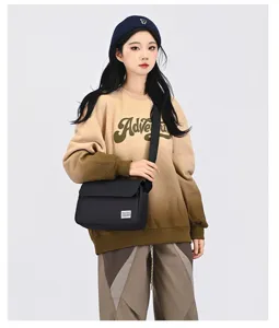 Detailaufnahme der schwarzen Canvas-Umhängetasche an einem weiblichen Modell im Freizeitlook