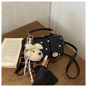 Polka dot pillow bag with cute poodle keychain and adjustable strap detail