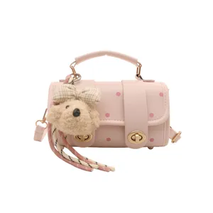 Cute pink polka dot pillow bag for girls featuring a plush puppy charm and top handle