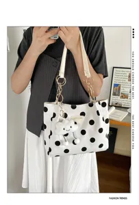 Detailed view of a stylish white canvas polka dot tote bag featuring a cute cloud charm