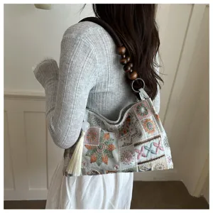 Dettaglio borsa tote in stile cinese con ricamo floreale e ciondolo con nappa elegante