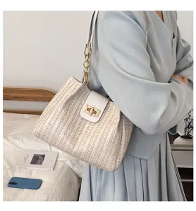 Vue détaillée d'un sac à bandoulière en paille tressée avec fermoir doré chic.
