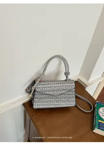 Dettaglio di una piccola borsa quadrata minimalista con trama intrecciata retrò