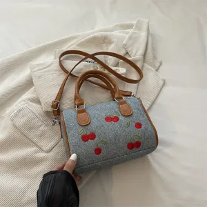 Stylish denim handbag with cherry embroidery, versatile shoulder and crossbody bag for women.