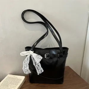 Grande borsa a secchiello nera con fibbia e fiocco in pizzo bianco elegante