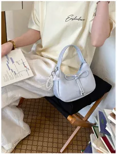 Nahaufnahme einer hellblauen Schultertasche mit Schleife im lässigen Lifestyle-Look