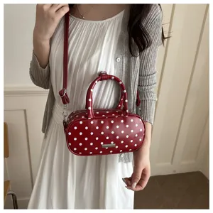Stijlvolle rode ovale handtas met stippen op een model voor een trendy zomerlook.