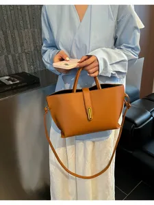 Bolso tote de cuero marrón retro sostenido por una modelo para un look de oficina