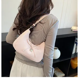 Vue arrière détaillée d'un sac dumpling rose avec nœud papillon porté par un modèle