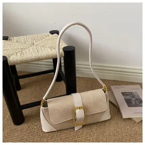 Elegant beige baguette bag with crocodile pattern and gold buckle detail