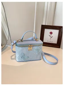 Elegante borsa vanity in jacquard celeste con farfalle 3D e dettagli metallici dorati.
